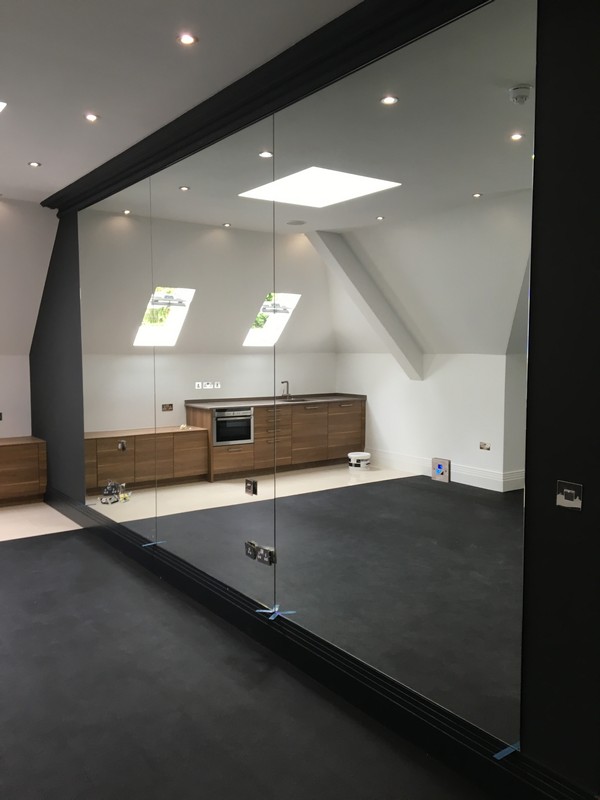 Frameless glass partition in loft conversion by Carshalton glaziers