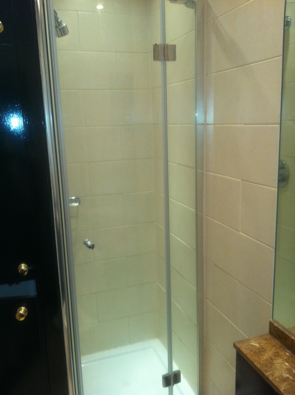 Frameless glass shower enclosure with chrome fittings in Carshalton