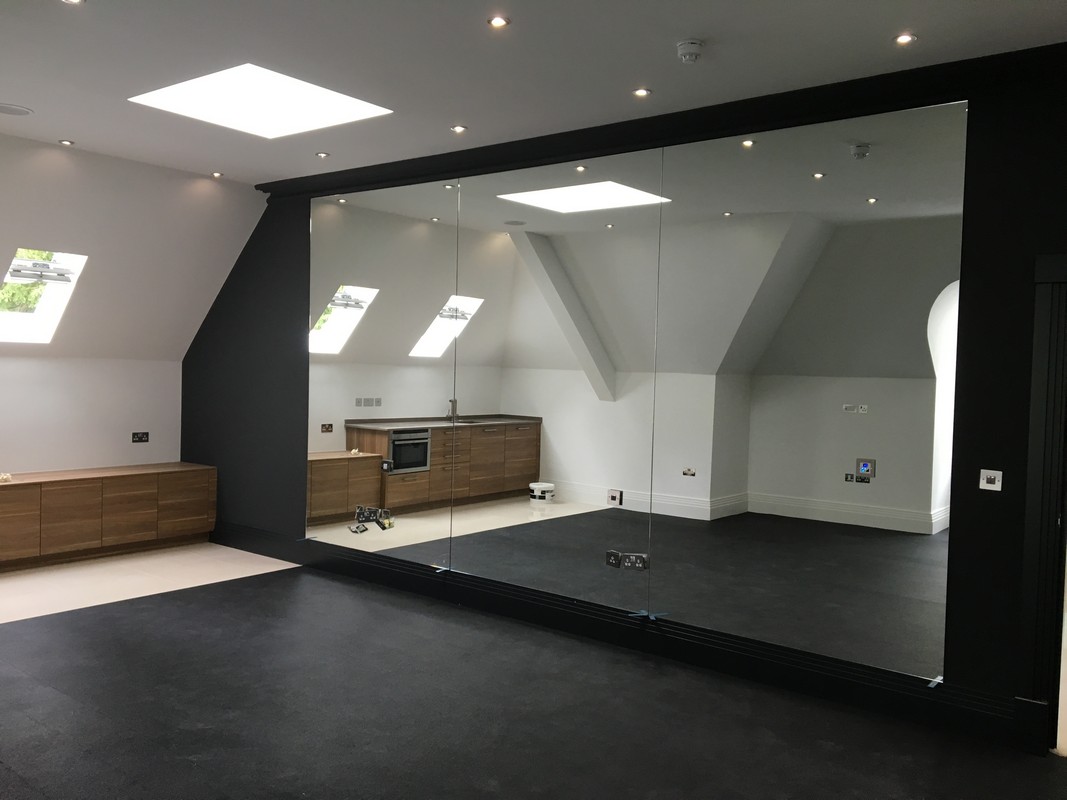 Frameless glass wall dividing loft conversion in Carshalton